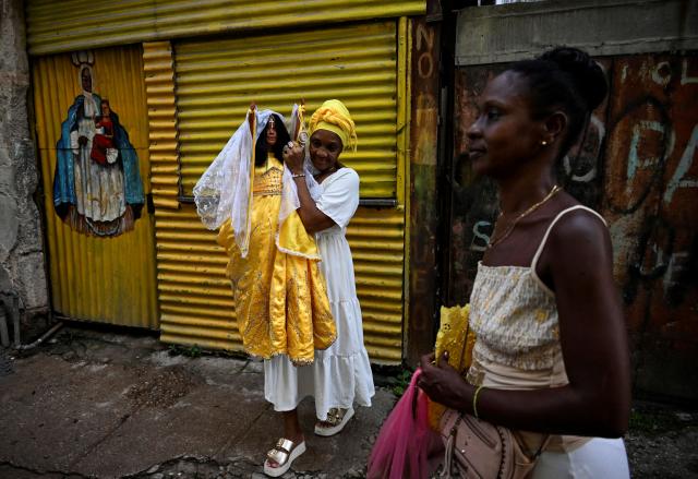 A follower of the Virgin of Charity, Oxun in the Yoruba religion, carry a doll as they attend a procession during the Oxun Day celebrations in havana on September 8, 2025. (Photo by YAMIL LAGE / AFP)