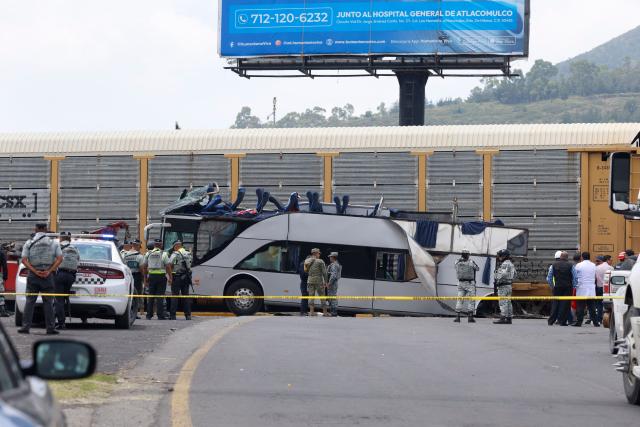 National guard members stand next to the wreckage of a passenger bus involved in an accident with a train in Atlacomulco, Mexico State, on September 8, 2025. According to the State of Mexico attorney general office, seven women and three men were killed in the accident. (Photo by Ramses VLADES / AFP)
