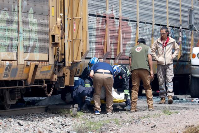 Rescue workers remove the body of one of the victims from the scene of an accident involving a passenger bus and a train in Atlacomulco, Mexico State, on September 8, 2025. According to the State of Mexico attorney general office, seven women and three men were killed in the accident. (Photo by Ramses VLADES / AFP)