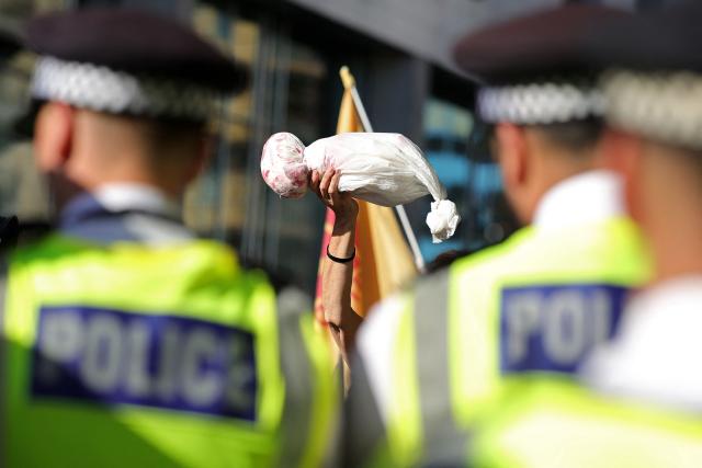 Police stand on duty as demonstrators protest outside the entrance to the Defence and Security Equipment International (DSEI) fair at the ExCeL centre, in east London, on September 9, 2025. A major arms fair opened Tuesday in London without the presence of Israeli government officials due to worsening diplomatic relations between Britain and Israel over the Gaza conflict. UK Prime Minister Keir Starmer's administration excluded the officials from the four-day event, but not the 51 Israeli defence companies that are set to attend including major arms manufacturer Elbit. (Photo by Toby Shepheard / AFP)