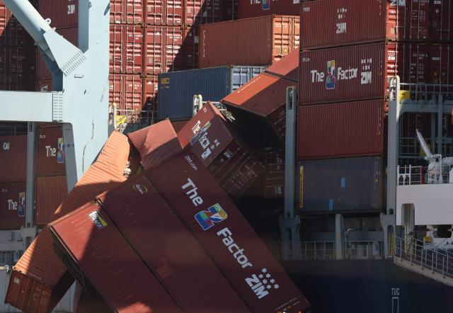 Fallen shipping containers are seen next to a vessel moored at the Port of Long Beach in Long Beach, California, on September 9, 2025. Dozens of shipping containers fell from the Portugal-registered ship called Mississippi at the major California port on September 9, 2025, halting operations as crews scrambled to limit the damage. (Photo by Patrick T. Fallon / AFP)