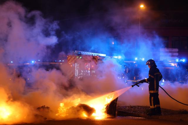 A firefighters extinguishes a fire at a roundabout, lit by protesters to block the access to the port of Brest, during a demonstration as part of the "Bloquons tout" ("Let's block everything") protest movement, in Brest, north-western France, on September 10, 2025. The broad anti-government campaign, dubbed "Bloquons tout" ("Let's block everything"), calls for a a shutdown of France on September 10 with a string of protest actions and civil disobedience around the country, while the handover of power between the new Prime Minister and his predecessor, who suffered a crushing loss in a confidence vote on September 8, is scheduled for the same day at noon. (Photo by FRED TANNEAU / AFP)