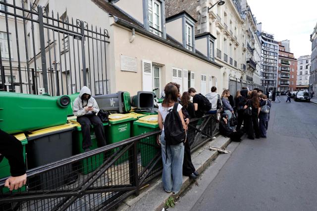 Students collect rubbish bins to set up a blockade at the entrance of the Lavoisier high school, as part the "Bloquons tout" ("Let's block everything") protest movement, in Paris, on September 10, 2025. The broad anti-government campaign, dubbed "Bloquons tout" ("Let's block everything"), calls for a a shutdown of France on September 10 with a string of protest actions and civil disobedience around the country, while the handover of power between the new Prime Minister and his predecessor, who suffered a crushing loss in a confidence vote on September 8, is scheduled for the same day at noon. (Photo by STEPHANE DE SAKUTIN / AFP)