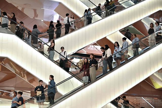 TOPSHOT - People use the escalators at Dusit Central Park shopping mall in Bangkok on September 11, 2025. (Photo by Lillian SUWANRUMPHA / AFP)