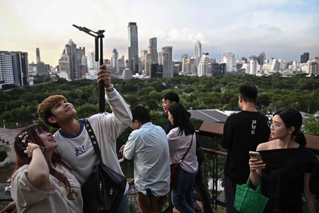 Visitors take pictures from a rooftop garden on top of Dusit Central Park shopping mall in Bangkok on September 11, 2025. (Photo by Lillian SUWANRUMPHA / AFP)