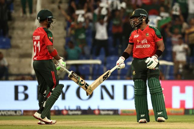 Bangladesh's Parvez Hossain Emon (R) and Tanzid Hasan touch their bats during the Asia Cup 2025 Twenty20 international cricket match between Bangladesh and Hong Kong at the Sheikh Zayed Cricket Stadium in Abu Dhabi on September 11, 2025. (Photo by Fadel SENNA / AFP)