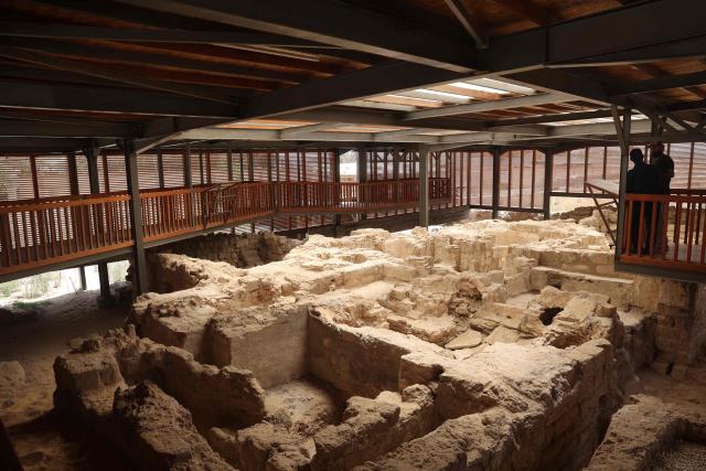 (FILES) People stand on a platform overlooking ruins at the archaeological site of the Saint Hilarion Monastery in Tell Umm al-Amr close to Deir al-Balah, in the central Gaza Strip on August 11, 2024. On September 11, 2025, nearly three decades of archaeological finds in Gaza were hurriedly evacuated  from a Gaza City building threatened by an Israeli strike, an official in charge of the antiquities told AFP. The depot in the building contained around 180 cubic metres of finds from Gaza's five main archaeological sites, including the fourth-century Saint Hilarion Monastery, listed as a UNESCO World Heritage site. (Photo by Eyad BABA / AFP)