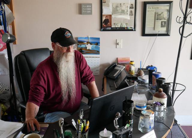 Allegheny Mountain Radio's general manager Scott Smith, sits at his desk at the radio station, in Monterey, Virginia, on September 2, 2025. Allegheny Mountain Radio is one of the many stations across the United States imperiled by President Donald Trump's funding cuts. At Trump's request, Republicans in Congress voted to cut federal money for the Corporation for Public Broadcasting, the key funding source for National Public Radio (NPR) and the Public Broadcasting Service (PBS), both of which conservatives have long accused of liberal bias. (Photo by Pierre HARDY / AFP)