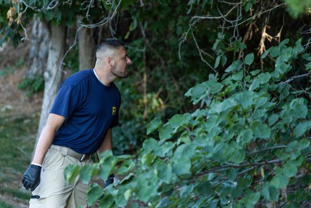 An agent with FBI forensic team searches near the scene where youth activist and influencer Charlie Kirk was shot during a public event at Utah Valley University in Orem, Utah, on September 11, 2025. The gunman who shot dead US right-wing youth leader Charlie Kirk in a targeted killing remained at large Thursday but authorities said they have video images of the suspect and have recovered a "high-powered" rifle. Kirk, a 31-year-old superstar on the Republican right who was credited with helping Donald Trump return to the presidency last year, was shot while addressing a large crowd at Utah Valley University on Wednesday. (Photo by Melissa MAJCHRZAK / AFP)