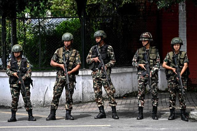 Army personnel keep watch outside the President House during a curfew imposed to restore law and order in Kathmandu on September 12, 2025. The army has imposed a curfew in the Himalayan nation of 30 million people, with soldiers patrolling the largely quiet streets after the worst violence in two decades. (Photo by Pedro Pardo / AFP)