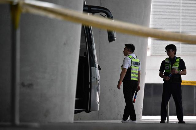 Members of security stand guard next to coaches parked outside Incheon International Airport in Incheon on September 12, 2025, before the arrival of a specially chartered Korean Air Boeing 747-81 (KE9036) bringing hundreds of South Korean workers back from Atlanta after their detention in a US immigration raid at a Hyundai-LG plant in Ellabell, Georgia. (Photo by Anthony WALLACE / AFP)