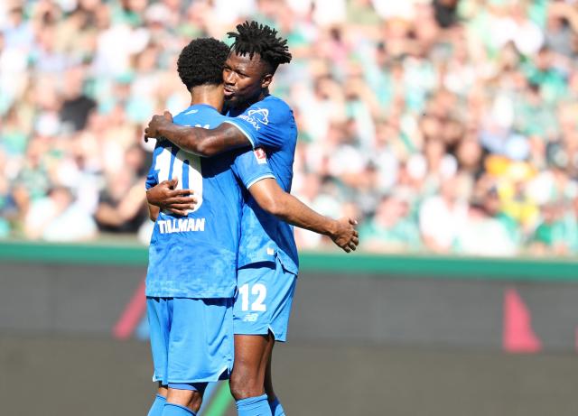 Bayer Leverkusen's Burkinabe defender #12 Edmond Tapsoba (R) hugs Bayer Leverkusen's US- German midfielder #10 Malik Tillman during the German first division Bundesliga football match between Werder Bremen and Bayer Leverkusen in Bremen on August 30, 2025. (Photo by Ibrahim OT / AFP) / DFL REGULATIONS PROHIBIT ANY USE OF PHOTOGRAPHS AS IMAGE SEQUENCES AND/OR QUASI-VIDEO