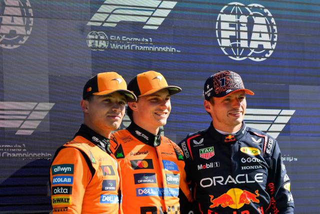 McLaren's Australian driver Oscar Piastri (C) poses flanked by second-placed McLaren's British driver Lando Norris (L) and third-placed Red Bull Racing's Dutch driver Max Verstappen after winning the pole position during the qualifying session of the Formula One Dutch Grand Prix at The Circuit Zandvoort, western Netherlands, on August 30, 2025. (Photo by JOHN THYS / AFP)