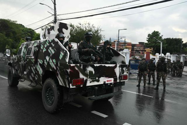 Nepal's army soldiers patrol on an armoured vehicle in front of the President House during a curfew imposed to restore law and order in Kathmandu, on September 12, 2025. Nepal's president and army sought on September 12 to find a consensus interim leader to fill a political vacuum after deadly anti-corruption protests toppled the government and left parliament in flames. (Photo by Arun SANKAR / AFP)