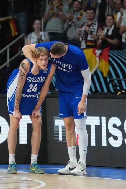 Finland's forward #24 Miikka Muurinen (L) and a team mates react after the end of the FIBA EuroBasket 2025 semi-final basketball match between Germany and Finland in Riga, Latvia, on September 12, 2025. (Photo by Gints Ivuskans / AFP)