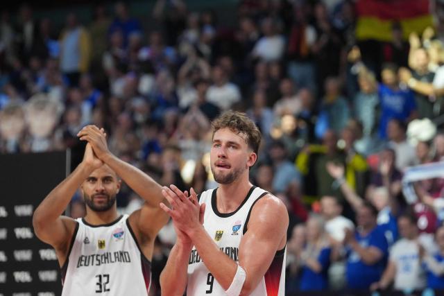 Germany's power forward #32 Johannes Thiemann (L) and Germany's guard #09 Franz Wagner celebrate after the end of the FIBA EuroBasket 2025 semi-final basketball match between Germany and Finland in Riga, Latvia, on September 12, 2025. (Photo by Gints Ivuskans / AFP)