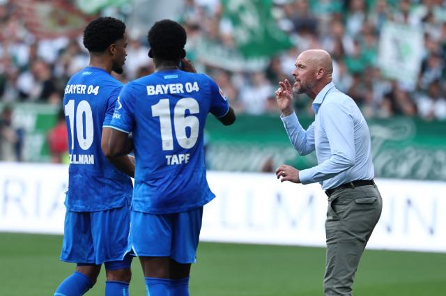 Bayer Leverkusen's Dutch head coach Erik ten Hag (R) talks to Bayer Leverkusen's US- German midfielder #10 Malik Tillman (L) and Bayer Leverkusen's French defender #16 Axel Tape during the German first division Bundesliga football match between Werder Bremen and Bayer Leverkusen in Bremen on August 30, 2025. (Photo by Ibrahim OT / AFP) / DFL REGULATIONS PROHIBIT ANY USE OF PHOTOGRAPHS AS IMAGE SEQUENCES AND/OR QUASI-VIDEO