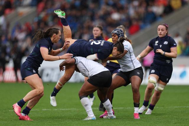 Scotland's center Lisa Thomson (C) is tackled by Fiji's number 8 Manuqalo Komaitai (CL) and Fiji's fly half Salanieta Kinita (CR) during the Women’s Rugby World Cup pool B match between Scotland and Fiji at Salford Community Stadium, Manchester, northwest England, on August 30, 2025. (Photo by Adrian Dennis / AFP)