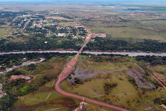 This aerial view shows the Guyana-Brazil border, near Lethem, on the Essequibo region, Guyana on August 27, 2025. ‘The Trail’ is the nickname given to the red dirt road stretching over 400 km from Georgetown, the capital of Guyana, to Lethem in the south on the Brazilian border, winding its way through equatorial forest, grasslands and hills and of  which Guyana wants to take advantage of to transform it into a major road to change the economic life of the country, but also open up the Essequibo, a region rich in gold and minerals largely claimed by Venezuela. (Photo by Joaquin Sarmiento / AFP)