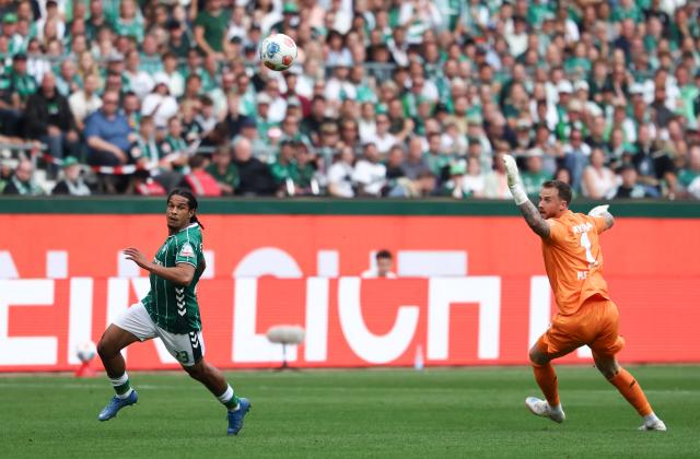 Bremen's Swiss defender #22 Isaac Schmidt (L) scores past Bayer Leverkusen's Dutch goalkeeper #01 Mark Flekken during the German first division Bundesliga football match between Werder Bremen and Bayer Leverkusen in Bremen on August 30, 2025. (Photo by Ibrahim OT / AFP) / DFL REGULATIONS PROHIBIT ANY USE OF PHOTOGRAPHS AS IMAGE SEQUENCES AND/OR QUASI-VIDEO