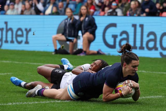 Scotland's wing Francesca McGhie (R) scores their fourth try beating Fiji's scrum half Kolora Lomani (L) during the Women’s Rugby World Cup pool B match between Scotland and Fiji at Salford Community Stadium, Manchester, northwest England, on August 30, 2025. (Photo by Adrian Dennis / AFP)