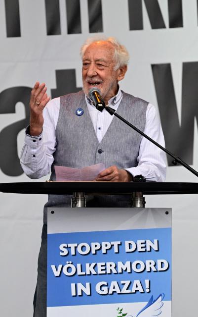 German actor Dieter Hallervorden stands behind a lectern reading "Stop the genocide in Gaza!" as he speaks on a stage during a rally titled "Stop the genocide in Gaza! No weapons in war zones! Peace instead of arms race!" on September 13, 2025 at the Brandenburg Gate in Berlin. (Photo by John MACDOUGALL / AFP)