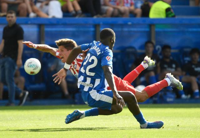 Atletico Madrid's Argentine forward #20 Giuliano Simeone falls as he fights for the ball with Alaves' Malian defender #22 Moussa Diarra during the Spanish league football match between Deportivo Alaves and Club Atletico de Madrid at the Mendizorroza stadium in Vitoria on August 30, 2025. (Photo by ANDER GILLENEA / AFP)