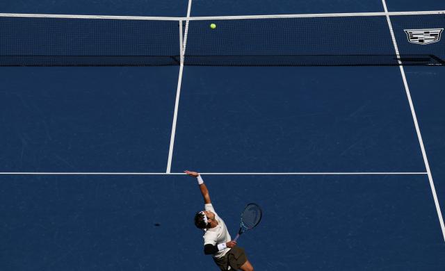 Italy's Lorenzo Musetti serves to Italy’s Flavio Cobolli during their men's singles third round match on day seven of the US Open tennis tournament at the USTA Billie Jean King National Tennis Center in New York City, on August 30, 2025. (Photo by TIMOTHY A. CLARY / AFP)