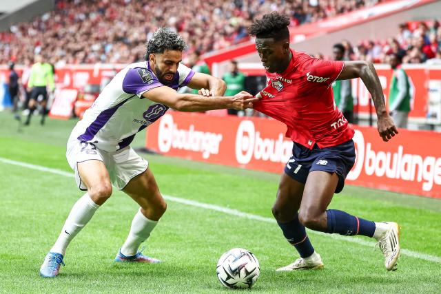 Toulouse's Algerian midfielder #22 Rafik Messali (L) fights for the ball with Lille's Portuguese forward #27 Felix Correia  during the French L1 football match between Lille LOSC and Toulouse FC at the Stade Pierre-Mauroy in Villeneuve-d'Ascq, northern France, on September 14, 2025. (Photo by Sameer Al-DOUMY / AFP)