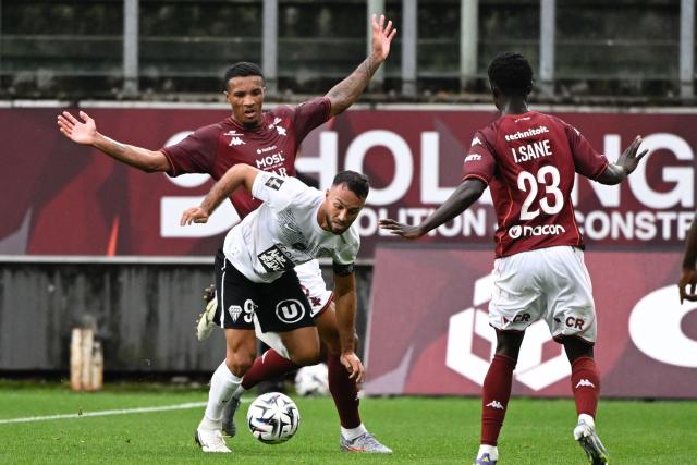 Angers’ Algerian midfielder #93  Haris Belkebla (front, L) fights for the ball with Metz’s Ivorian defender #05 Jean-Philippe Gbamin (back, L) during the French L1 football match between FC Metz and SCO Angers at Saint-Symphorien stadium in Longeville-les-Metz, on September 14, 2025. (Photo by Jean-Christophe VERHAEGEN / AFP)