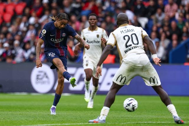 Paris Saint-Germain's French forward #29 Bradley Barcola (L) shoots and scores his team's second goal during the French L1 football match between Paris Saint-Germain (PSG) and RC Lens at the Parc des Princes stadium in Paris, on September 14, 2025. (Photo by FRANCK FIFE / AFP)