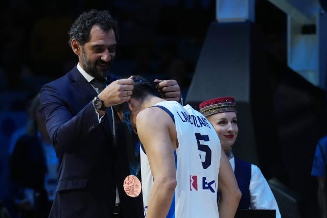 Greece's guard #05 Giannoulis Larentzakis (C) receives his bronze medal from President of FIBA Europe Jorge Garbajosa (L) after winning third place in the FIBA EuroBasket 2025 small final basketball match between Greece and Finland in Riga, Latvia, on September 14, 2025. (Photo by Gints Ivuskans / AFP)