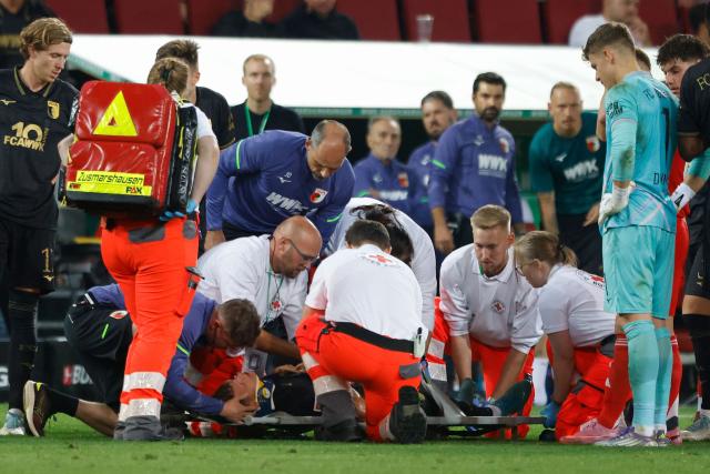 Augsburg's German midfielder #19 Robin Fellhauer receives medical attention following a clash of heads during the German first division Bundesliga football match between FC Augsburg and FC Bayern Munich in Augsburg, southern Germany, on August 30, 2025. (Photo by Michaela STACHE / AFP) / DFL REGULATIONS PROHIBIT ANY USE OF PHOTOGRAPHS AS IMAGE SEQUENCES AND/OR QUASI-VIDEO