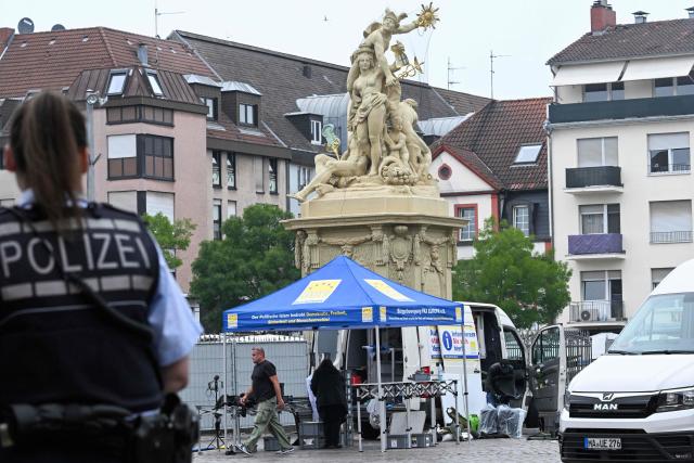 (FILES) A police officer looks on as workers pack up the gear at the scene where several people were injured in a knife attack on May 31, 2024 in Mannheim, western Germany. On September 16, 2025, the verdict is expected in the trial of an Afghan man accused of a deadly jihadist stabbing, during which a police officer was killed, and for attempting to murder five others at the market square in Mannheim, southwestern Germany on May 31, 2024. (Photo by Kirill KUDRYAVTSEV / AFP)