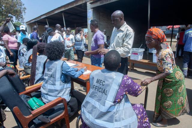 Malawi Electoral Commission (MEC) officials assist voters before they cast their ballots at the Lilongwe District Commissioner’s office polling station at Old town in Lilongwe on September 16, 2025 during Malawi's presidential and parliamentary elections. Malawi went to the polls on September 16, 2025 with the incumbent president and his predecessor vying for a second chance to govern the largely poor southern African nation battered by soaring costs and fuel shortages. (Photo by Amos GUMULIRA / AFP)