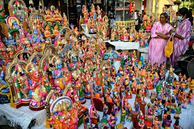 Customers look at idols of Hindu deities and mythical figures displayed for sale at a stall ahead of the 'Navaratri' festival in Chennai on September 16, 2025. (Photo by R. Satish BABU / AFP)