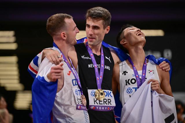 (L-R) Bronze medallist Czech Republic's athlete Jan Stefela,  Gold medallist New Zealand's athlete Hamish Kerr and silver medallist South Korea's Sanghyeok Woo celebrate after the men's high jump final during the World Athletics Championships in Tokyo on September 16, 2025. (Photo by Ben STANSALL / AFP)