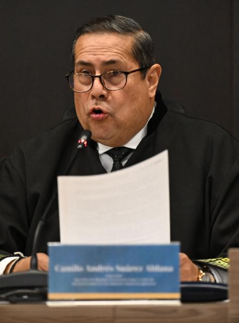 Special Jurisdiction of Peace (JEP) magistrate Camilo Suarez speaks at the sentence hearing of former FARC guerrilla leaders over kidnapping crimes committed during the Colombian armed conflict, at the JEP headquarters in Bogota on September 16, 2025. (Photo by RAUL ARBOLEDA / AFP)