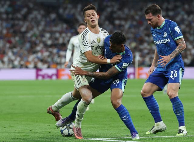 Marseille's Italian defender #33 Emerson Palmieri fights for the ball with Real Madrid's Turkish midfielder #15 Arda Guler during the UEFA Champions League first round day 1 football match between Real Madrid CF and Olympique de Marseille at the Santiago Bernabeu stadium in Madrid on September 16, 2025. (Photo by Pierre-Philippe MARCOU / AFP)