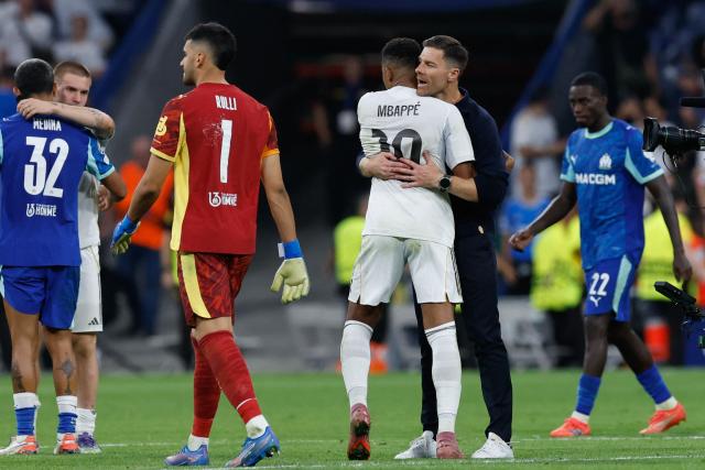 Real Madrid's Spanish coach Xabi Alonso (R) embraces Real Madrid's French forward #10 Kylian Mbappe at the end of the UEFA Champions League first round day 1 football match between Real Madrid CF and Olympique de Marseille at the Santiago Bernabeu stadium in Madrid on September 16, 2025. Real Madrid won 2-1. (Photo by Oscar DEL POZO / AFP)