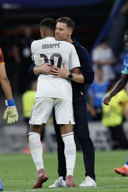 Real Madrid's Spanish coach Xabi Alonso (R) embraces Real Madrid's French forward #10 Kylian Mbappe at the end of the UEFA Champions League first round day 1 football match between Real Madrid CF and Olympique de Marseille at the Santiago Bernabeu stadium in Madrid on September 16, 2025. Real Madrid won 2-1. (Photo by Oscar DEL POZO / AFP)