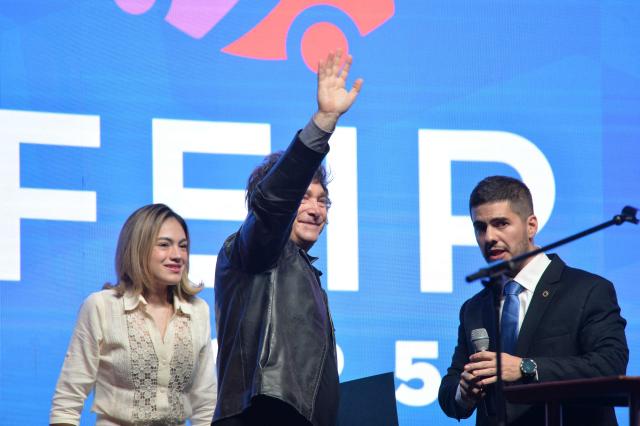 Argentina's President Javier Milei (C) waves as he arrives to a meeting with young people from the Industrial Entrepreneurs Forum of Paraguay (FEIP) at the headquarters of the National Sports Secretariat (SND) in Asuncion on September 16, 2025. (Photo by Daniel DUARTE / AFP)