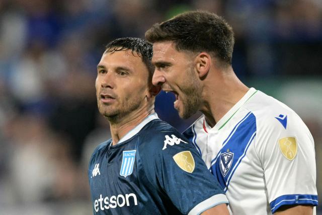 Velez Sarsfield's defender #18 Lisandro Magallan argues with Racing's forward #09 Adrian Martinez during the Copa Libertadores quarterfinal first leg all-Argentine football match between Velez Sarsfield and Racing at the Jose Amalfitani Stadium in Buenos Aires on September 16, 2025. (Photo by JUAN MABROMATA / AFP)