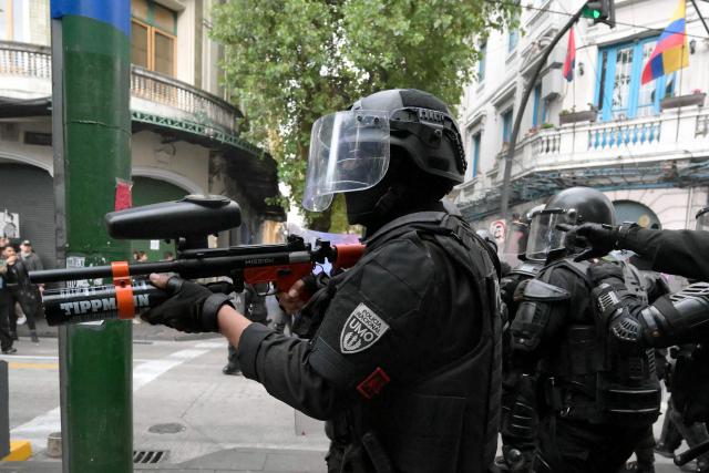 An Ecuadorian riot police officer stands guard during a protest against President Daniel Noboa's cuts and the elimination of diesel subsidy within a state of emergency declared by the government in Quito on September 16, 2025. (Photo by Rodrigo BUENDIA / AFP)