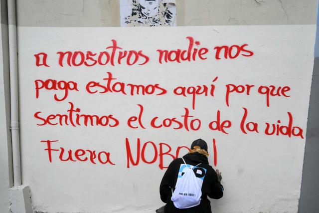 A demonstrator paints a graffiti during a protest against Ecuadorian President Daniel Noboa's cuts and the elimination of diesel subsidy within a state of emergency declared by the government in Quito on September 16, 2025. (Photo by Rodrigo BUENDIA / AFP)