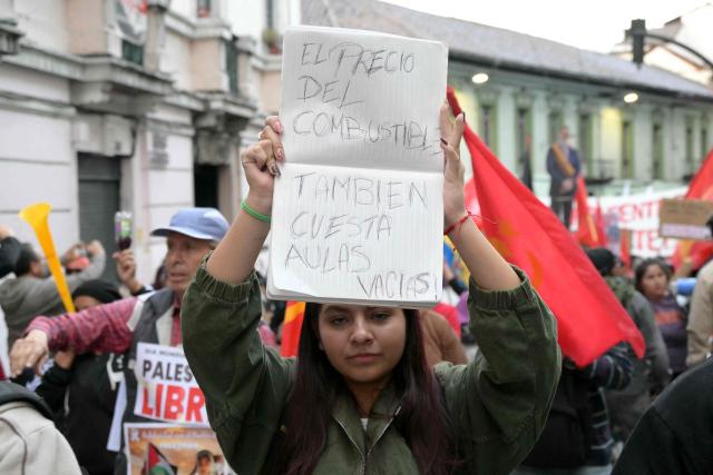 A demonstrator holds a sign that reads "The price of fuel also costs empty classrooms" during a protest against Ecuadorian President Daniel Noboa's cuts and the elimination of diesel subsidy within a state of emergency declared by the government in Quito on September 16, 2025. (Photo by Rodrigo BUENDIA / AFP)