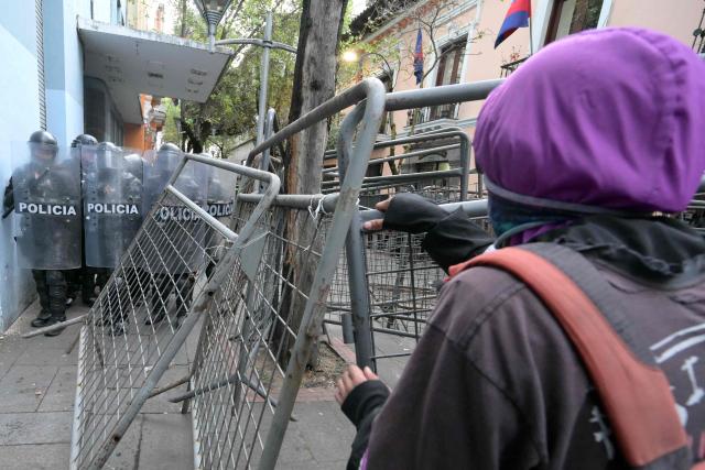A demonstrator faces off with Ecuadorian riot police during a protest against President Daniel Noboa's cuts and the elimination of diesel subsidy within a state of emergency declared by the government in Quito on September 16, 2025. (Photo by Rodrigo BUENDIA / AFP)