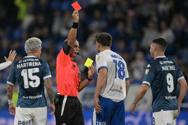 Brazilian referee Wilton Pereira Sampaio shows a red card to Velez Sarsfield's defender #18 Lisandro Magallan -following his second yellow card- during the Copa Libertadores quarterfinal first leg all-Argentine football match between Velez Sarsfield and Racing at the Jose Amalfitani Stadium in Buenos Aires on September 16, 2025. (Photo by JUAN MABROMATA / AFP)