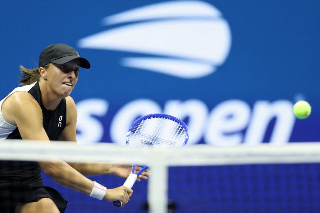 Poland's Iga Swiatek plays a backhand return to Russia's Anna Kalinskaya during their women's singles third round match against on day seven of the US Open tennis tournament at the USTA Billie Jean King National Tennis Center in New York City, on August 30, 2025. (Photo by CHARLY TRIBALLEAU / AFP)