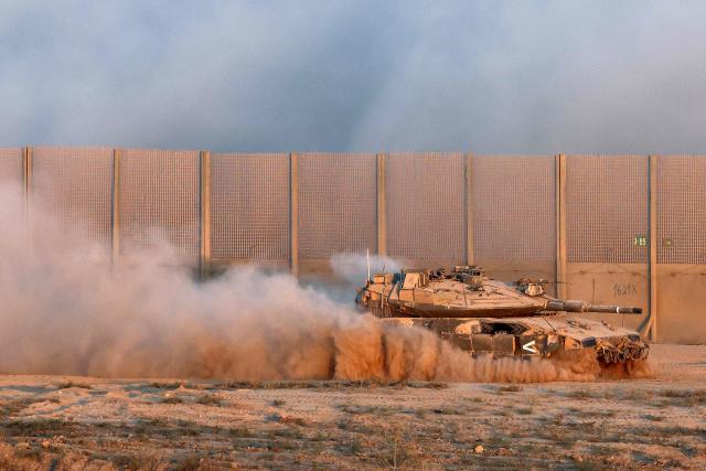 An Israeli military armoured vehicle moves near the border fence with the Gaza Strip on September 17, 2025. Israel launched its ground assault on Gaza City before dawn on September 16, shortly after the US Secretary of State's visit expressing robust support for the offensive, while a United Nations probe charged Israel with committing "genocide" in the Palestinian territory and accused its Prime Minister and other top officials of incitement. (Photo by Jack GUEZ / AFP)